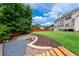 Landscaped backyard featuring retaining wall, mulched beds, stone steps, and green lawn at 6585 Canyon Cv, Cumming, GA 30028