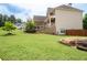 Lush green backyard featuring a large lawn, mature trees, and professional landscaping at 6585 Canyon Cv, Cumming, GA 30028