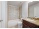Bathroom featuring a tub with tile surround, granite countertop, and wood vanity at 6585 Canyon Cv, Cumming, GA 30028
