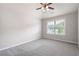 Bright bedroom with plush carpeting, a ceiling fan, and a window offering natural light at 6585 Canyon Cv, Cumming, GA 30028