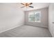 Cozy bedroom featuring plush carpeting, a ceiling fan, and a window for ample natural light at 6585 Canyon Cv, Cumming, GA 30028