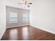 Bedroom featuring hardwood floors and two windows allowing ample natural light at 6585 Canyon Cv, Cumming, GA 30028
