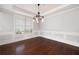 Formal dining room with hardwood floors, wainscoting, and a decorative chandelier at 6585 Canyon Cv, Cumming, GA 30028