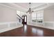 Formal dining room featuring hardwood floors, elegant chandelier, and large windows for natural light at 6585 Canyon Cv, Cumming, GA 30028