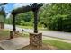 Attractive entrance to Parkstone community showing arbor with stone base and lush landscaping on a sunny day at 6585 Canyon Cv, Cumming, GA 30028