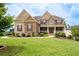 Beautiful two-story brick home with a manicured front lawn and covered entryway at 6585 Canyon Cv, Cumming, GA 30028