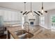 Kitchen with granite counters, stainless appliances, and view to Gathering room with fireplace at 6585 Canyon Cv, Cumming, GA 30028