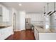 Modern kitchen with white cabinets, stainless steel appliances, and a granite-topped island at 6585 Canyon Cv, Cumming, GA 30028