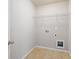 Functional laundry room space with tile flooring, utility hookups, and shelving at 6585 Canyon Cv, Cumming, GA 30028