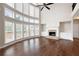 Bright living room boasts hardwood floors, large windows, and a brick fireplace at 6585 Canyon Cv, Cumming, GA 30028