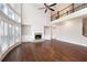 Bright living room featuring hardwood floors, high ceilings, and a cozy fireplace at 6585 Canyon Cv, Cumming, GA 30028