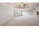 Spacious primary bedroom with carpet, a ceiling fan, and a large window at 6585 Canyon Cv, Cumming, GA 30028