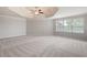 Large primary bedroom featuring neutral carpet, ceiling fan, and tray ceiling detail at 6585 Canyon Cv, Cumming, GA 30028