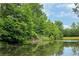 The pond in the community offers a tranquil escape, reflecting the surrounding trees and sky in its calm waters at 6585 Canyon Cv, Cumming, GA 30028