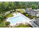 A beautiful community pool and clubhouse surrounded by lush landscaping and mature trees at 6585 Canyon Cv, Cumming, GA 30028