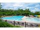 Community pool featuring a large swimming area, splash pad with colorful features, and lounge chairs at 6585 Canyon Cv, Cumming, GA 30028