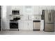 Well-lit kitchen boasts stainless steel appliances, white cabinets and a large window at 1473 Lansing Se St, Atlanta, GA 30315