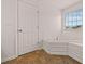 Bathroom featuring a large soaking tub, tile flooring, and window at 211 Millstone Dr, Hampton, GA 30228