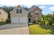 Charming two-story home with stone accents, manicured lawn, and a two-car garage at 211 Millstone Dr, Hampton, GA 30228