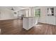 Open concept kitchen island with white cabinets and view of adjacent living room at 211 Millstone Dr, Hampton, GA 30228