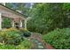 Lush backyard with a stone pathway and stairs leading up to the covered patio and home at 2115 Howell Mill Nw Rd, Atlanta, GA 30318