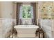 Beautiful bathroom showcasing a standalone tub, marble walls and flooring, and a frameless glass shower at 2115 Howell Mill Nw Rd, Atlanta, GA 30318