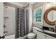 A well-kept bathroom includes a shower with a gray-patterned curtain, modern sink, and a natural-wood mirror at 2115 Howell Mill Nw Rd, Atlanta, GA 30318