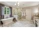 A luxurious bathroom boasting a soaking tub, elegant chandelier, and frameless glass shower at 2115 Howell Mill Nw Rd, Atlanta, GA 30318