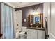 Bathroom featuring a shower/tub, blue patterned shower curtain, white vanity, and framed mirror at 2115 Howell Mill Nw Rd, Atlanta, GA 30318