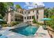 Rear exterior view of a home with a pool, covered patio, and beautifully landscaped grounds at 2115 Howell Mill Nw Rd, Atlanta, GA 30318