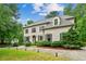 Stately two-story home with a white brick exterior, black shutters, and beautifully landscaped front yard at 2115 Howell Mill Nw Rd, Atlanta, GA 30318