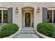 Charming brick home featuring a arched front door, stone steps, and manicured landscaping at 2115 Howell Mill Nw Rd, Atlanta, GA 30318