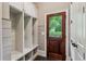 Well-organized mudroom with built-in storage and a wooden door leading to the outside at 2115 Howell Mill Nw Rd, Atlanta, GA 30318