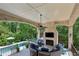 Covered outdoor living space featuring a fireplace and comfortable seating overlooking the pool at 2115 Howell Mill Nw Rd, Atlanta, GA 30318