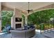 Inviting covered patio with a fireplace, ceiling fan, and cozy outdoor seating arrangement at 2115 Howell Mill Nw Rd, Atlanta, GA 30318
