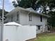 Exterior elevation featuring siding, mature trees, white fence, and meticulous landscaping at 4312 Idlewood Ln, Tucker, GA 30084