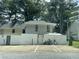 View of exterior featuring a two-story design with siding, white fence, parking spaces and mature trees at 4312 Idlewood Ln, Tucker, GA 30084