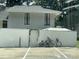 Exterior showcasing parking spaces, building address, with a white fence, and lush, mature trees at 4312 Idlewood Ln, Tucker, GA 30084