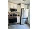 Kitchen with stainless steel appliances, white cabinets, and gray tile flooring at 4312 Idlewood Ln, Tucker, GA 30084