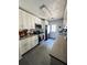 Galley kitchen featuring white cabinets, grey tile flooring, and stainless steel appliances at 4312 Idlewood Ln, Tucker, GA 30084
