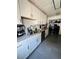 Galley kitchen featuring white cabinets, grey tile flooring, stainless steel appliances and laundry area at 4312 Idlewood Ln, Tucker, GA 30084