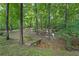 Scenic backyard featuring a small bridge over a creek and a swing set area nestled among the trees at 4070 Feather Dr, Douglasville, GA 30135