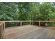 View of the wooden back deck with metal railings and backyard trees at 4070 Feather Dr, Douglasville, GA 30135