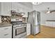 Renovated eat-in kitchen features stainless steel appliances, hardwood floors and decorative backsplash at 4070 Feather Dr, Douglasville, GA 30135