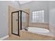 Bathroom featuring a soaking tub and glass shower enclosure at 7030 Mandevilla Ln, Douglasville, GA 30135