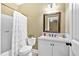 Bright bathroom features white vanity with granite countertop, framed mirror, and shower-tub combo at 7030 Mandevilla Ln, Douglasville, GA 30135