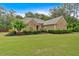 Well-maintained single-story home with stone accents, manicured landscaping, and lush green lawn at 7030 Mandevilla Ln, Douglasville, GA 30135