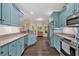 Bright kitchen with light blue cabinets, granite countertops, and stainless steel appliances at 7030 Mandevilla Ln, Douglasville, GA 30135