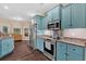 Stylish kitchen with modern stainless steel appliances, granite countertops, and bright teal cabinetry at 7030 Mandevilla Ln, Douglasville, GA 30135