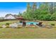 Sparkling backyard pool with lounge chairs, verdant landscaping, and shady umbrella on green lawn at 7030 Mandevilla Ln, Douglasville, GA 30135